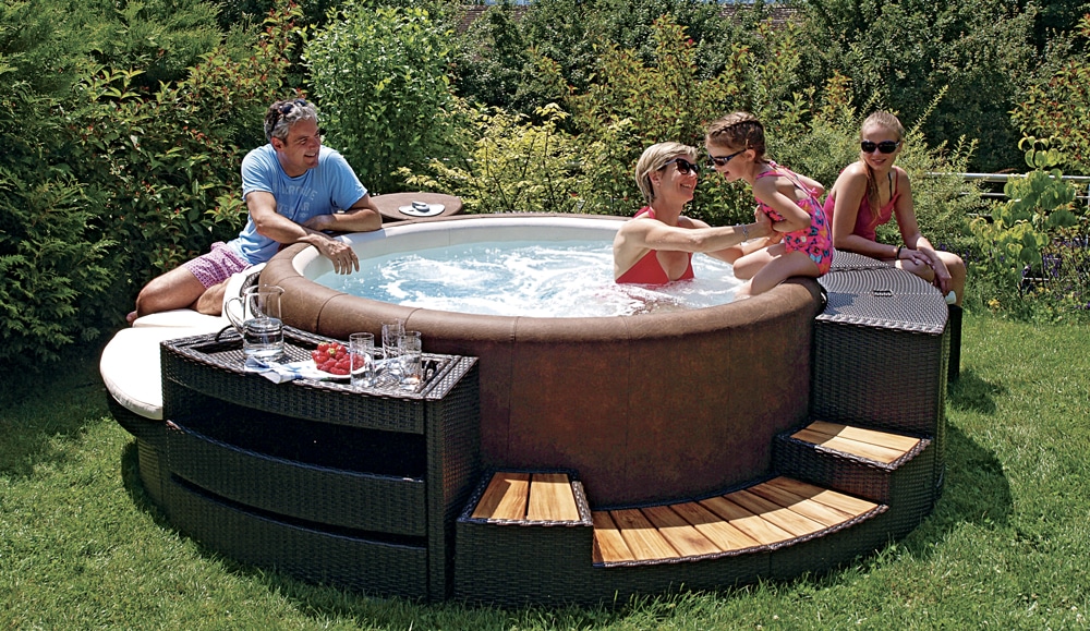 Softub spa, hard spa on which a family plays with a little girl sitting on the spa